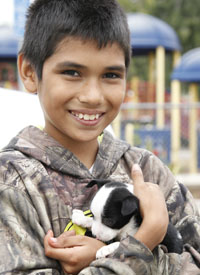 Boy holds his puppy at a Pets for Life clinic