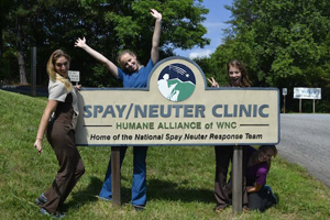 Students pose next to Humane Alliance's sign