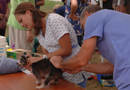 Student and veterinarian examine a dog at a Pets for Life event in Los Angeles