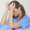 female medical professional with head in hands (credit: iStockphoto)